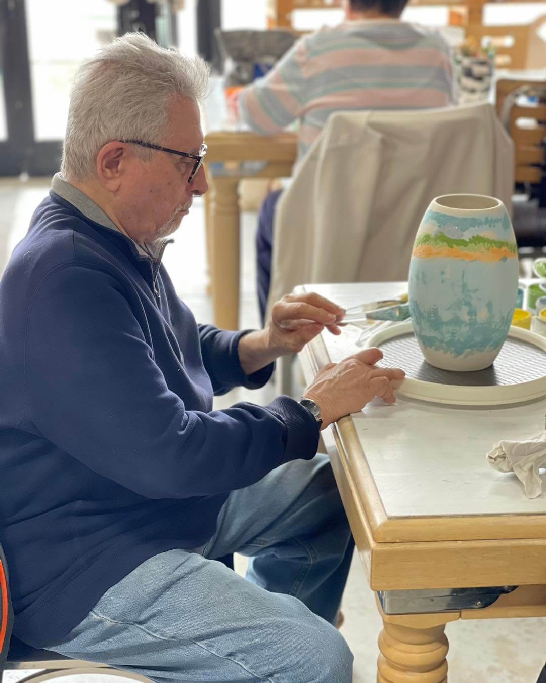 senior man painting a pot