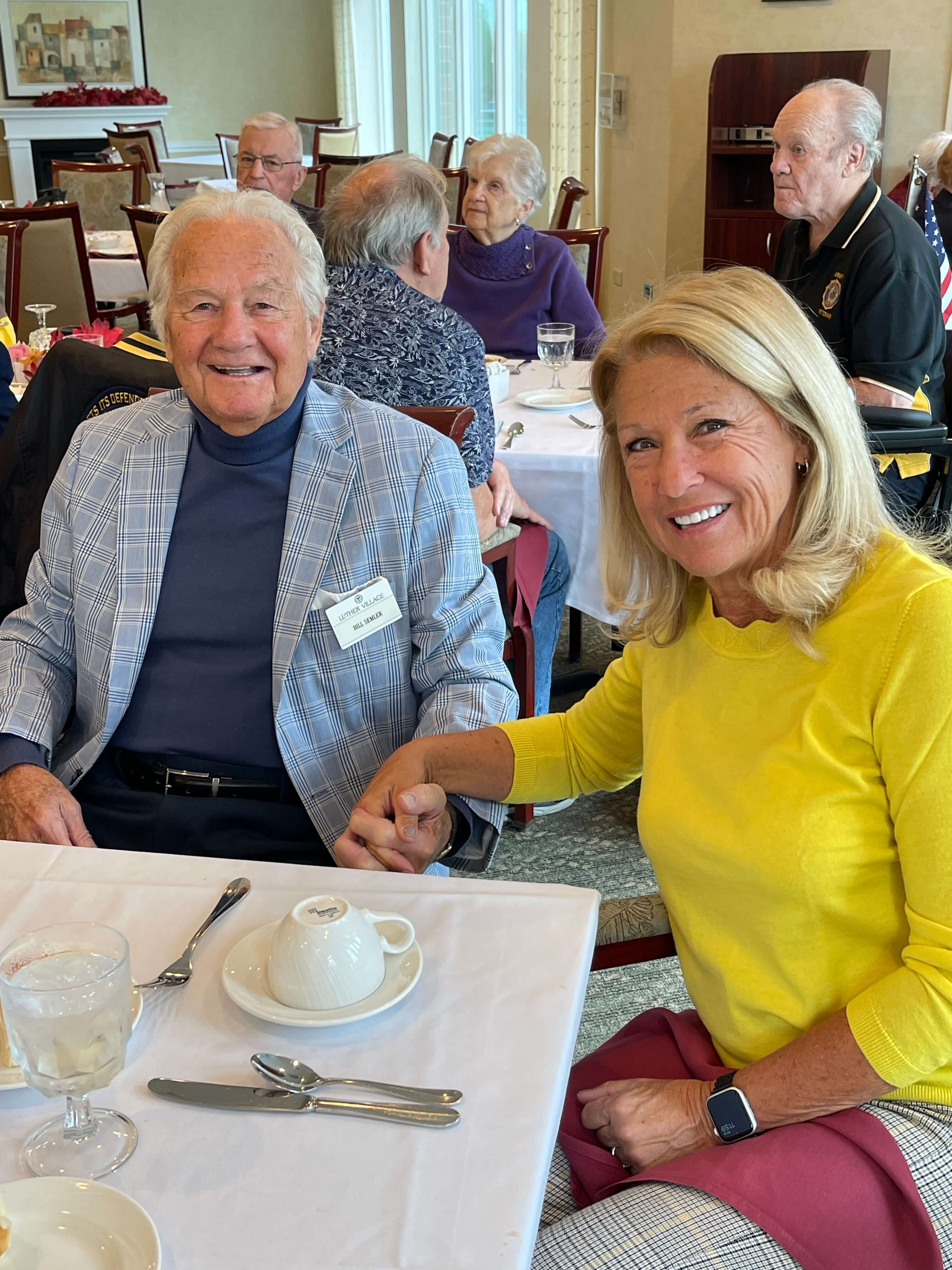 senior couple holding hands at lunch