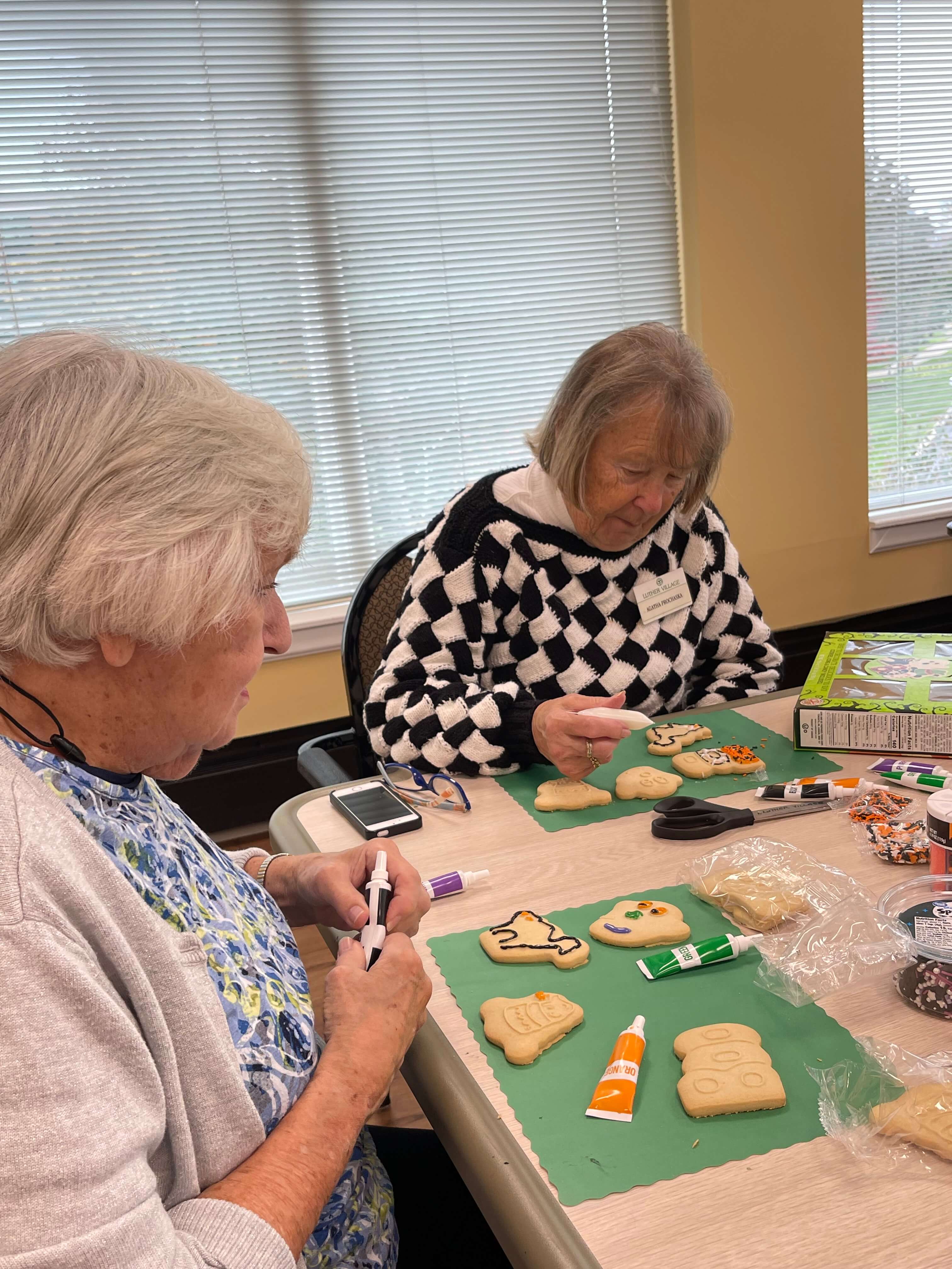 senior women decorating cookies